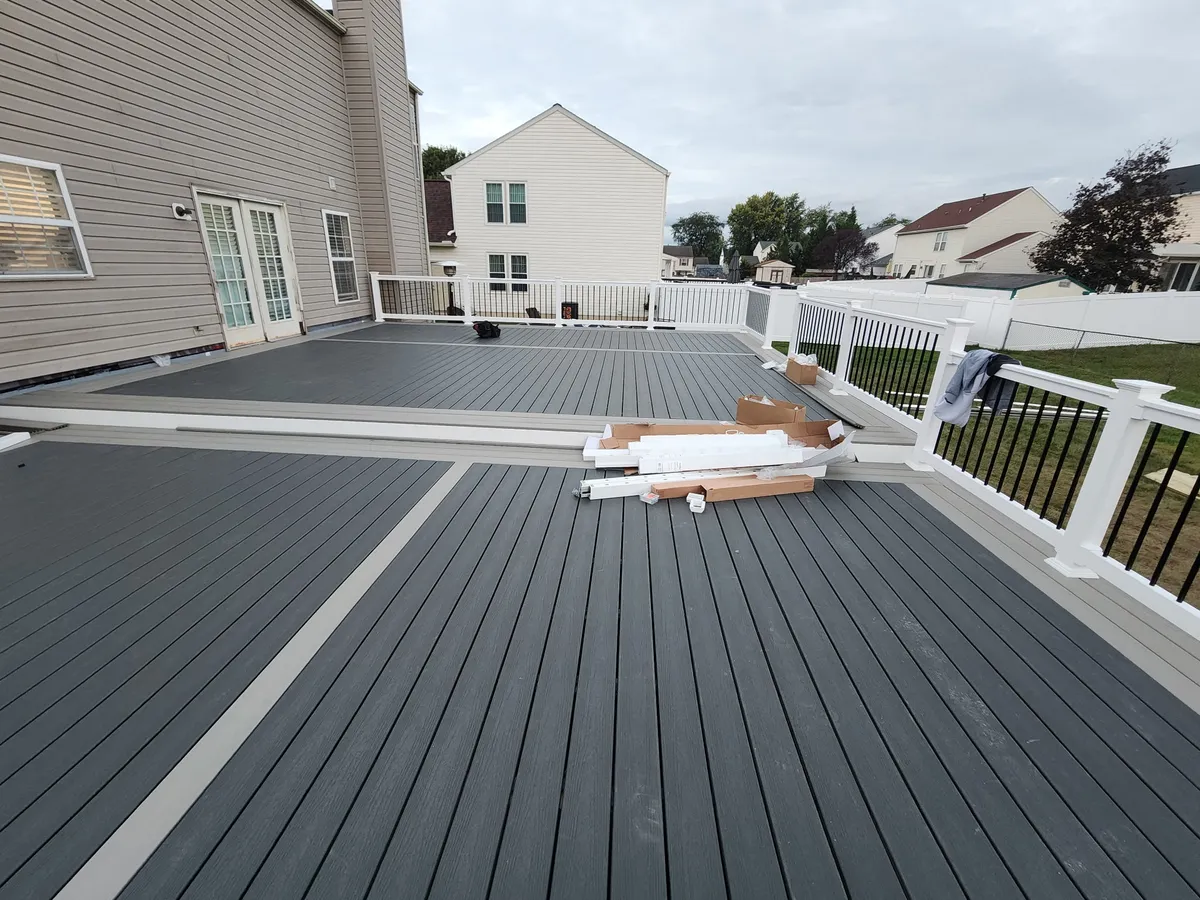 Composite deck with white vinyl railing nearing completion